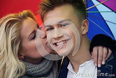 Pretty couple kissing under an umbrella Stock Photo