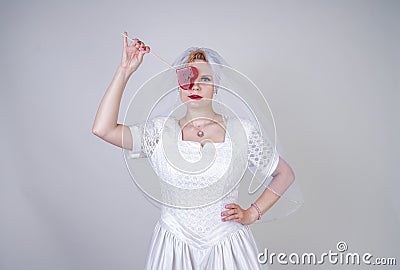 Pretty curvy adult woman with short hair wearing long vintage wedding dress with sun style skirt. young caucasian bride with veil Stock Photo