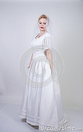 Pretty curvy adult woman with short hair wearing long vintage wedding dress with sun style skirt. young caucasian bride with veil Stock Photo
