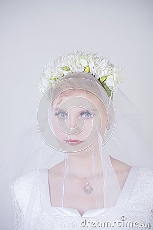 Pretty curvy adult woman with short hair wearing long vintage wedding dress with sun style skirt. young caucasian bride with veil Stock Photo