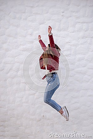Pretty curvy girl jumping sideways next to a peculiar white wall Stock Photo