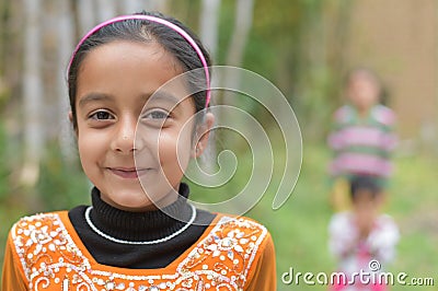 Pretty Cute young Indian girl child smiling with soft green natural backdrop Stock Photo