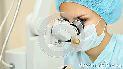 Pretty doctor woman portrait. Ophthalmology laser microscope operation. Clinic room. Patient eye treatment Stock Photo