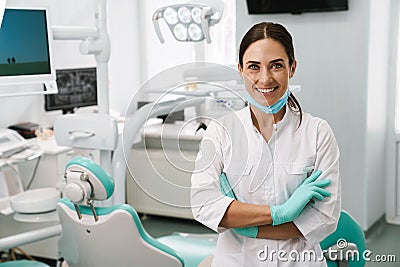 European mid dentist woman smiling while standing in dental clinic Stock Photo