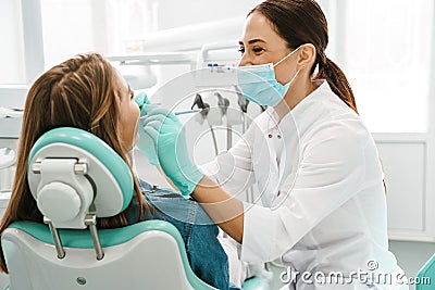 European mid happy dentist woman in face mask working in dental clinic Stock Photo