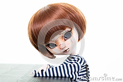 Pretty expressive doll with big eyes red hairs in blue shirt in white background Stock Photo