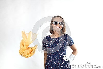Pretty expressive lady wearing a polka dots dress white sunglasses and yellow scarf in the studio Stock Photo