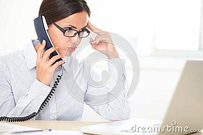 Pretty female executive conversing on the phone Stock Photo