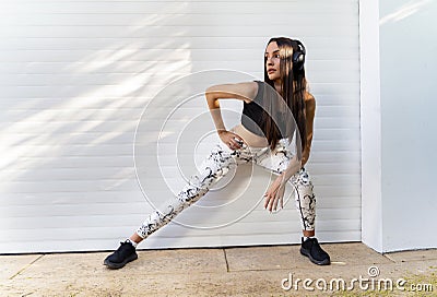 Pretty female runner, stretching legs, warming up Stock Photo