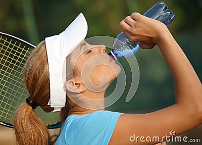 Pretty female tennis player drinking water Stock Photo