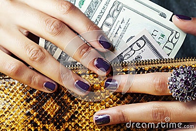 Pretty fingers of african american woman holding money closeup with purse, luxury jewellery on python clutch, cash for Stock Photo