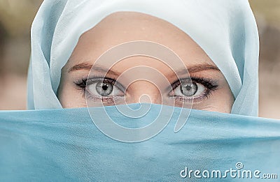 Pretty girl with beautiful big blue eyes, big eyelashes and eyebrows. Portrait of beautiful woman with blue eyes wearing blue sc Stock Photo