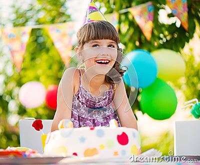 Pretty girl with cake at birthday party Stock Photo