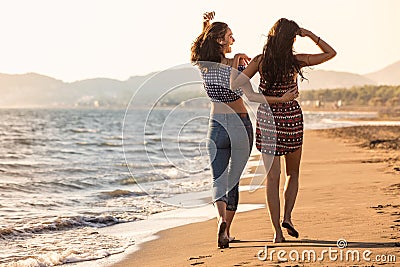 Pretty girl has a fun with her girlfriend on the beach Stock Photo