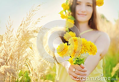 Pretty girl holding bouquet in the sunny summer grass field Stock Photo