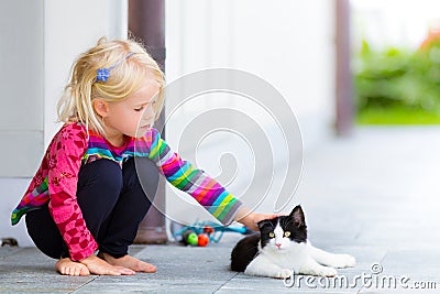 Pretty girl patting a cat outside Stock Photo