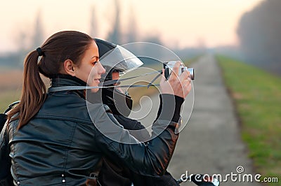 Pretty girl photographing nature from motorcycle Stock Photo