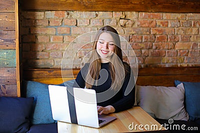 Pretty girl with red lips using laptop at cafe. Stock Photo