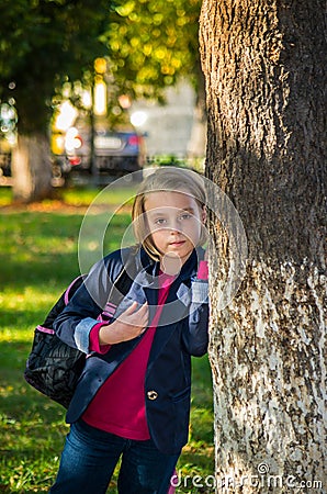 Pretty girl of school age in the autumn park. Stock Photo