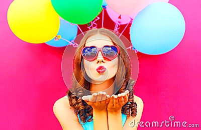 Pretty girl sends an air kiss holds an air colorful balloons Stock Photo
