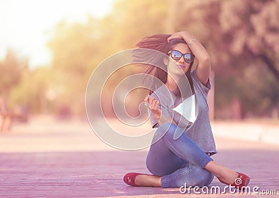 Pretty girl sitting on the floor with moving hair Stock Photo