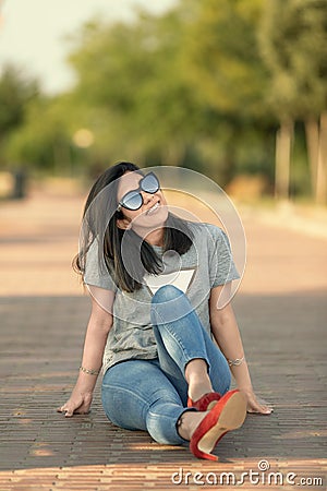 Pretty girl sitting on the floor looking up Stock Photo