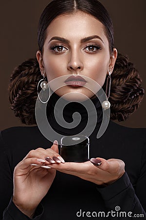 Pretty girl, unusual hairstyle, bright makeup, red lips and manicure design with a jar of nail polish in her hands Stock Photo