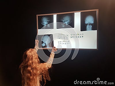 Pretty girl uses a negatoscope to view important information. Stock Photo