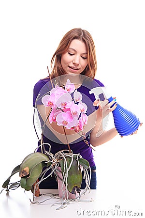 Pretty girl watering orchid flower with spray Stock Photo