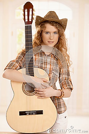 Pretty guitarplayer girl embracing guitar Stock Photo