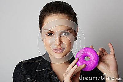 Pretty handsome girl holding hand colorful donuts against her face over white background. Attractive young woman with Stock Photo