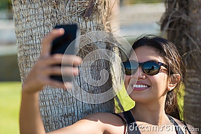 Pretty happy woman taking herself photo by mobile Stock Photo