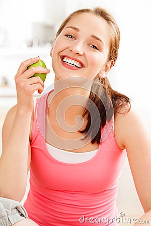 Pretty healthy young woman smiling holding a green apple Stock Photo