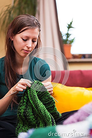 Pretty knitting woman on a couch Stock Photo