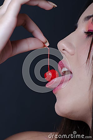 Pretty lady with fleshy lips, biting a sweet cherry Stock Photo
