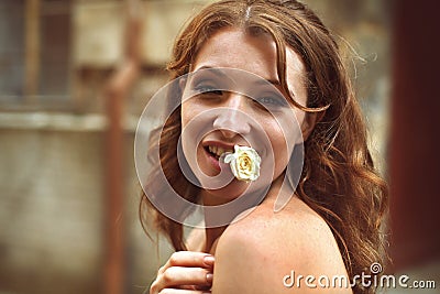 Pretty lady holds a white rose in her mouth Stock Photo