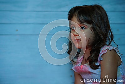 Pretty little girl with big eyes looks with interest from the side Stock Photo