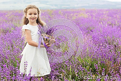 Pretty little girl in lavender field with basket Stock Photo