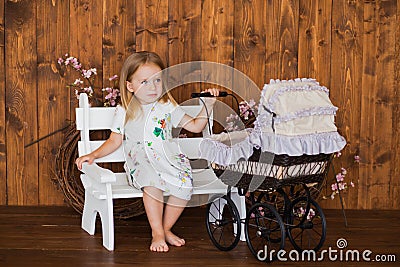Pretty little girl play with retro pram, baby stroller Stock Photo