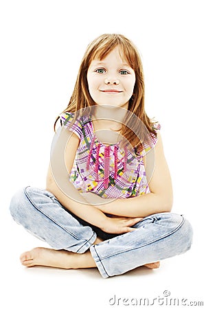 Pretty little girl sitting on the floor in jeans Stock Photo