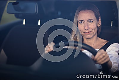 Pretty midle aged woman at the steering wheel of her car Stock Photo