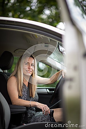Pretty midle aged woman at the steering wheel of her car Stock Photo