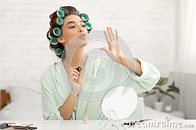 Pretty Millennial Lady Blowing At Nails Making Manicure At Home Stock Photo