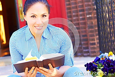 Pretty Mixed Race Woman Reading Holy Bible Stock Photo