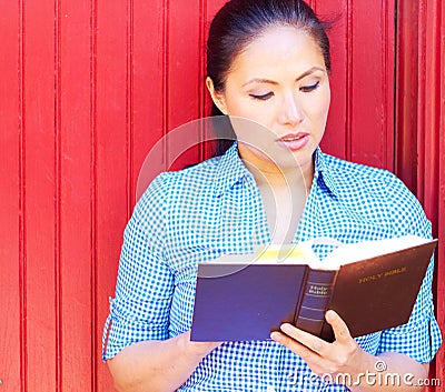 Pretty Mixed Race Woman Reading Holy Bible Stock Photo