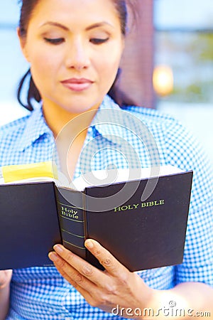 Pretty Mixed Race Woman Reading Holy Bible Stock Photo