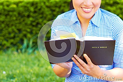 Pretty Mixed Race Woman Reading Holy Bible Stock Photo