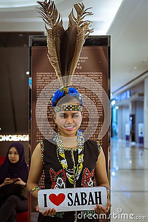 A pretty Murut lady in traditional costume and holding I LOVE SABAH sign Editorial Stock Photo