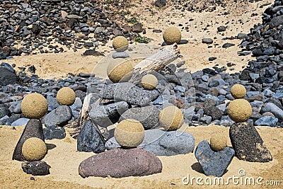 Pretty pile of wooden pebbles and balls of sand facing the sea Stock Photo