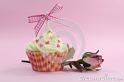 Pretty pink cupcake with pale pink silk rose bud Stock Photo